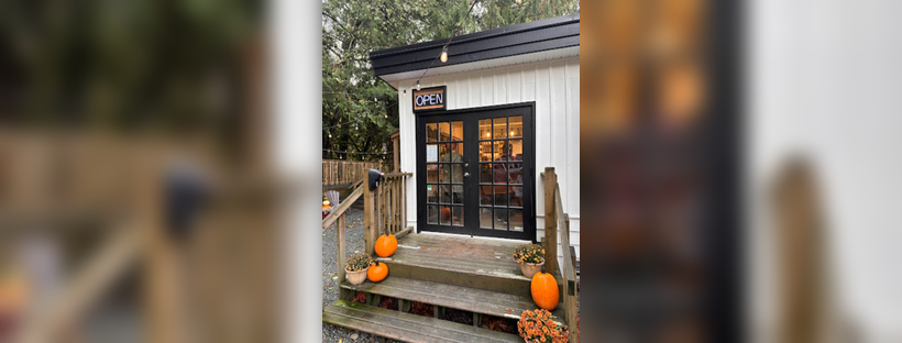 A cafe entrance featuring a welcoming door and a charming porch, surrounded by a serene outdoor setting.